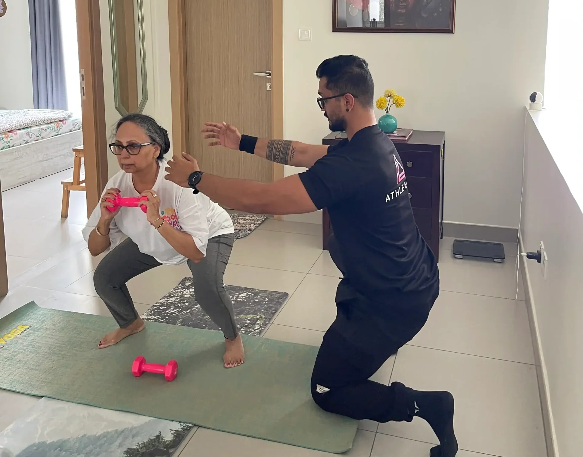 Woman in her forties strength training at home in Dubai with a personal trainer