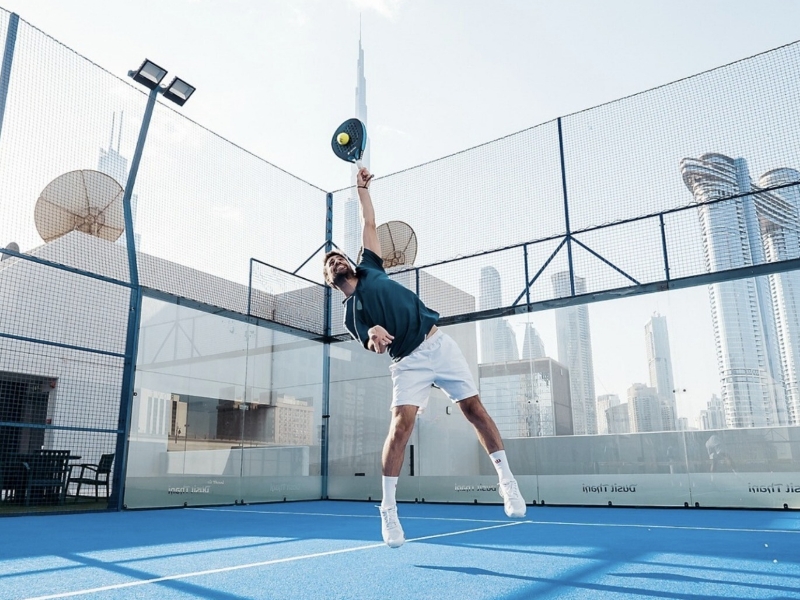 Padel player lunging on a Dubai court showing common injury risk patterns